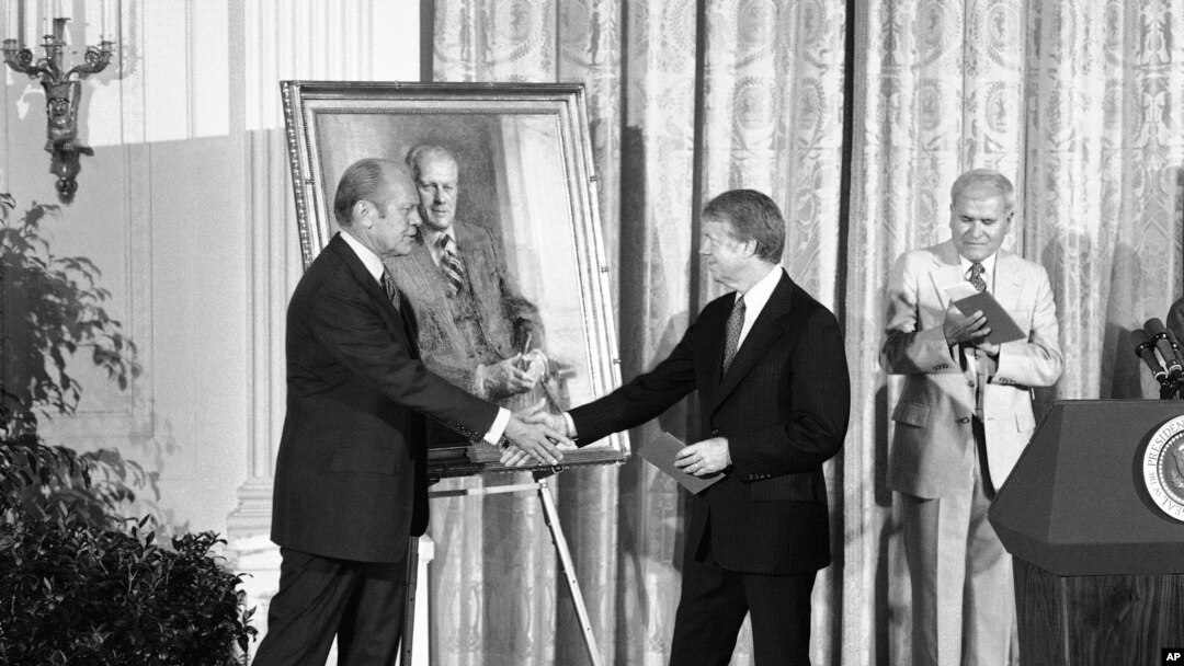 FILE - President Jimmy Carter shakes hands with former President Gerald R. Ford in the White House in Washington on May 24, 1978 during the unveiling of Ford's portrait.