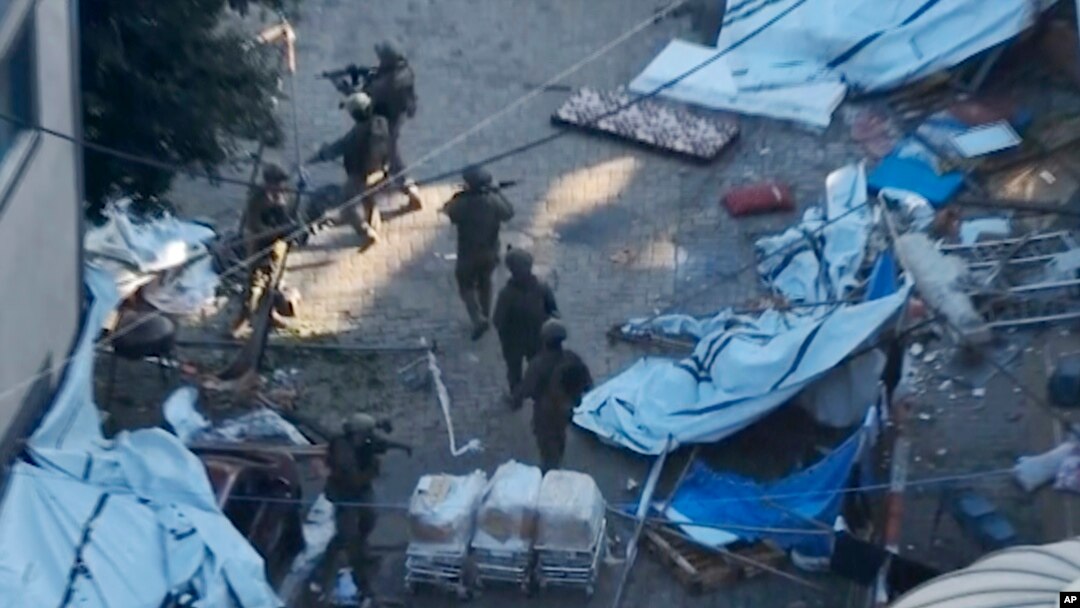 In this image taken from a video released by the Israeli Defense Forces, Nov. 15, 2023, Israeli soldiers walk in the area of Al-Shifa hospital in Gaza City. 