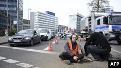 Police remove an activist of the environmental group 'Last Generation' (Letzte Generation) sitting on the ground to cause a traffic jam near Berlin's Ernst-Reuter-Platz central place during a climate action in Berlin, Germany, April 24, 2023.