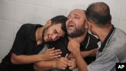 The father of Mohammad al-Habil weeps with his relatives after his son was killed with his uncle, Abdul Muti al-Habil, in Deir al Balah, Gaza Strip, June 14, 2024.