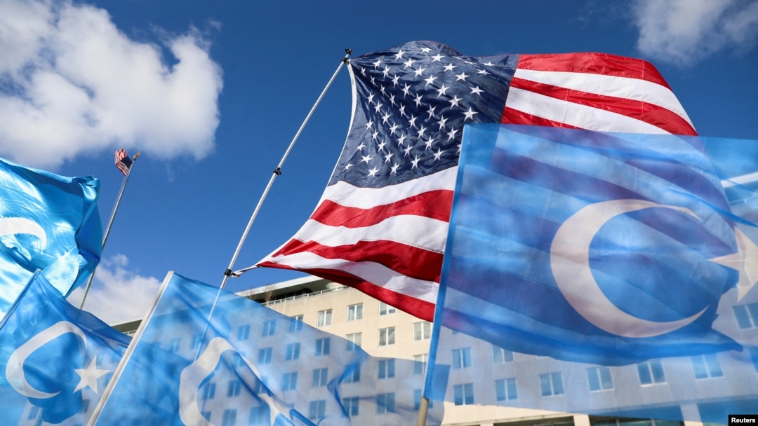 FILE — Flags fly during a rally for Uyghur citizens of China in Washington on Nov. 28, 2022. 