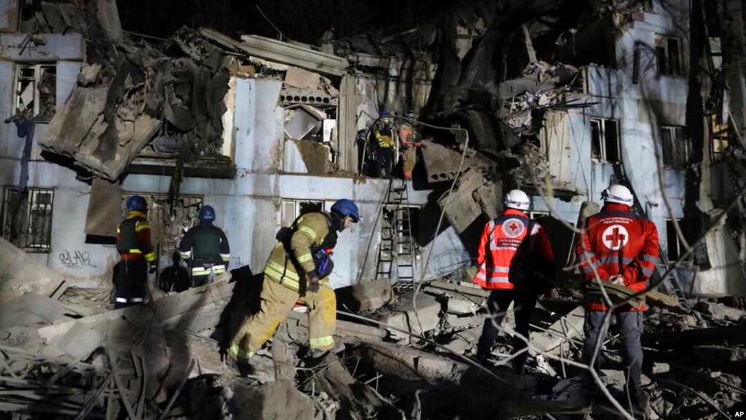 Ukrainian State Emergency Service firefighters inspect a damaged house after Russian shelling hit in Zaporizhzhia, Ukraine, March 2, 2023.