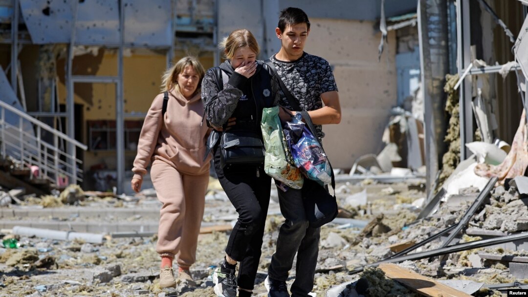 Employees leave a restaurant building hit by recent shelling that local Russian-installed authorities called a Ukrainian military strike in Donetsk, Russian-controlled Ukraine, May 11, 2024.