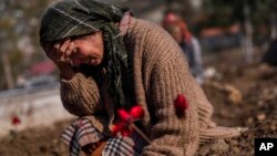 FILE - A member of the Vehibe family who lost a relative during the recent earthquakes mourns during the victim's burial in Antakya, southeastern Turkey, Feb. 11, 2023.