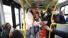 Marlene Alfonso, una abuela venezolana de 69 años que se hace llamar “Toothless Cindy”, acepta monedas de los viajeros mientras canta sobre la vida de los inmigrantes venezolanos en un autobus en Bogotá, Colombia, el martes 3 de noviembre de 2020.