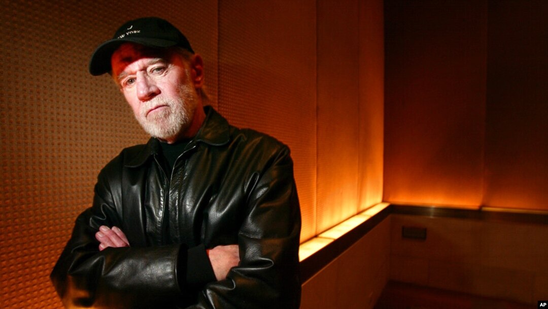 FILE - Actor and comedian George Carlin poses in a New York hotel, March 19, 2004. Carlin's estate is suing a media company over an hour-long special which uses a synthesis of the late comedian to deliver commentary on current events.