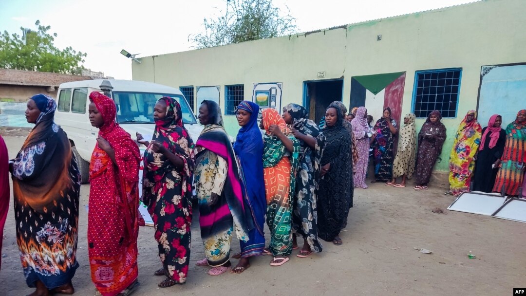 FILE - Internally displaced women wait to collect aid from a group at a camp in Gadaref on May 12, 2024, while clashes reignited between the Sudanese army and rival paramilitaries in the key Darfur town of El Fasher.