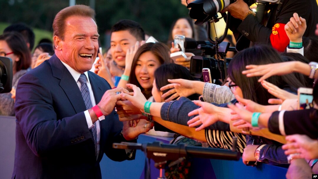 Actor and former Governor of California Arnold Schwarzenegger shakes hands with Chinese fans as he arrives for the grand opening of the 5th annual Beijing International Film Festival in Beijing, April 16, 2015. 