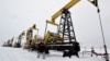 FILE - A worker walks past pump jacks at an oil field east of Izhevsk, Russia, Dec. 7, 2007. 