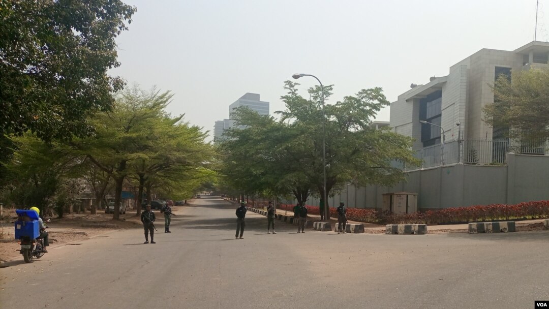 Armed security men stand guard on a road that leads to the Russian consulate in Abuja, Nigeria, Feb. 28, 2022. (Timothy Obiezu/VOA)