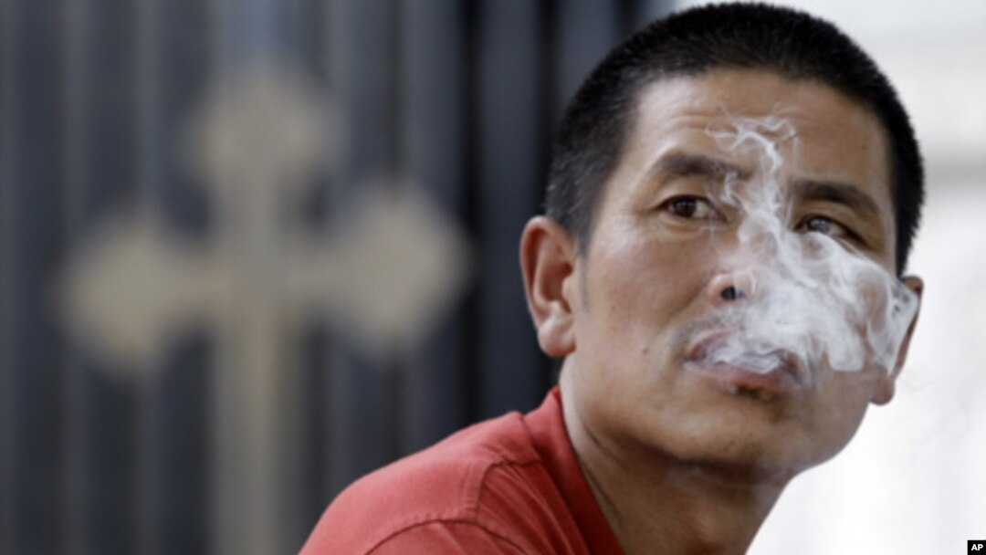 一名男子在北京一家教堂外吸煙(資料圖片)