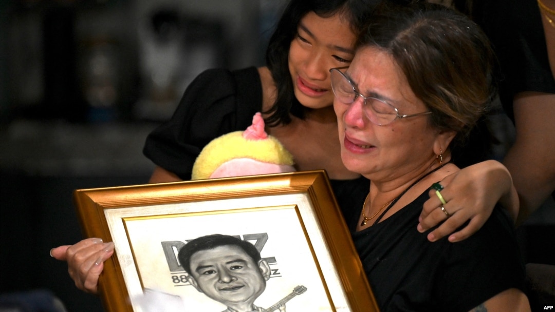 Family members grieve the loss of journalist Percival Mabasa at their home in Las Pinas, suburban Manila, Oct. 4, 2022.
