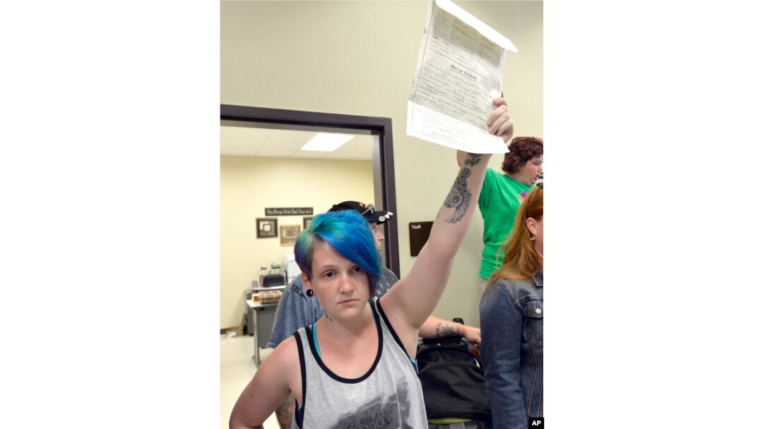 Lexie Colon holds up her marriage certificate at the Rowan County Courthouse in Morehead, Ky., Sept. 1, 2015. Signed by clerk Kim Davis, it certifies her marriage to Camryn Colon, a transgender male.