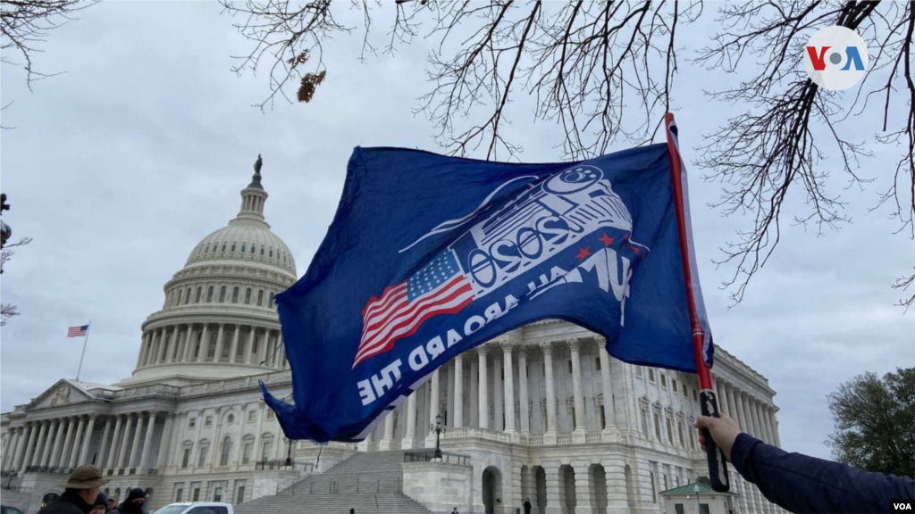 Partidario de Trump alza una bandera que dice "Todos abordo del tren de Trump".