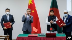 资料照片: 2022年8月7日中国外交部长王毅(左二)和孟加拉国外长莫门(右二)在达卡签署协议
