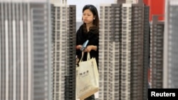 资料照：湖北武汉一名女子正在一个新楼盘售楼处观看。
