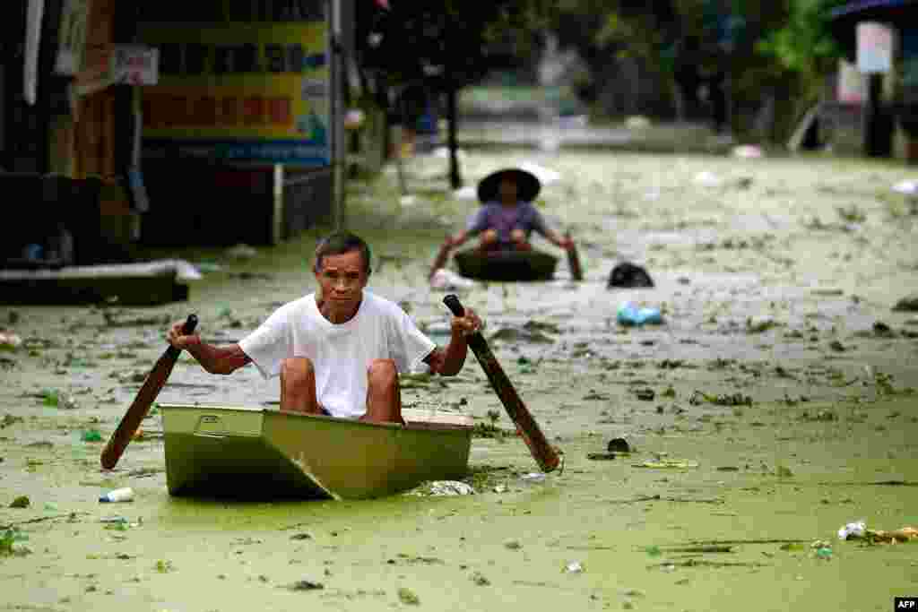 People row along floodwaters in Hanoi's suburban Chuong My district, Vietnam.