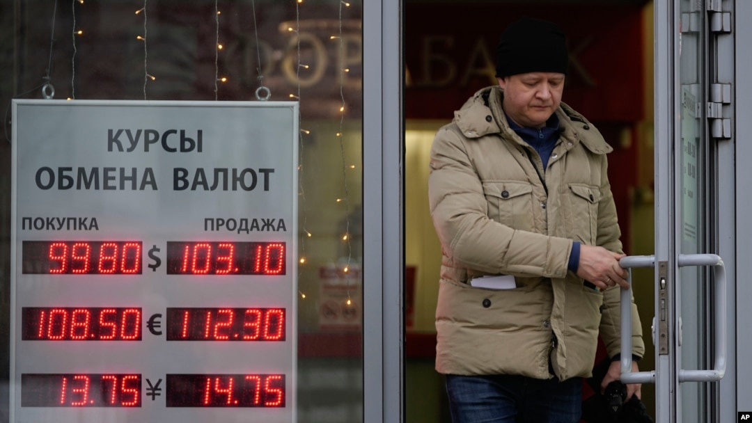 FILE - A man leaves a bank displaying currency exchange rates in Moscow, Dec. 20, 2024. 