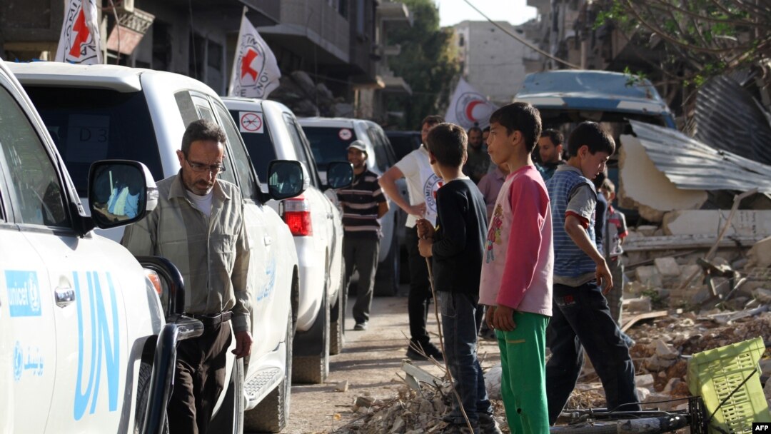 Vehicles of the International Committee of the Red Cross (ICRC), the Syrian Arab Red Crescent and the United Nations wait on a street after an aid convoy entered the rebel-held Syrian town of Daraya, southwest of the capital Damascus, on June 1, 2016.