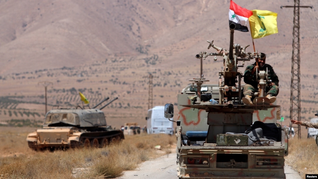 Hezbollah and Syrian flags flutter on a military vehicle in Western Qalamoun, Syria, Aug, 28, 2017.