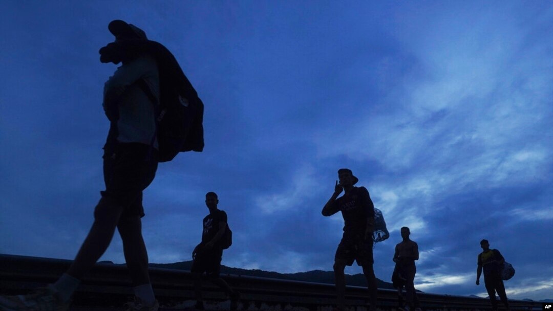 Migrantes caminan hacia el norte por la carretera hacia la salida a Huixtla, estado de Chiapas, México, al amanecer del jueves 9 de junio de 2022. 