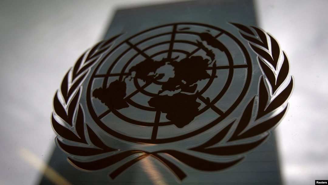 FILE - The United Nations headquarters building is pictured though a window with the U.N. logo in the foreground in New York, Aug. 15, 2014. 