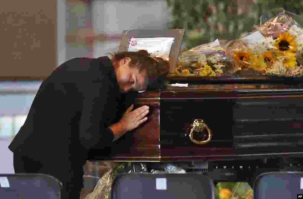 A woman mourns a victim of a collapsed highway bridge, at the Fiera di Genova exhibition center, where some of the coffins are laid in state, in Genoa, Italy. A state funeral for most of the victims will take place in Genoa on Saturday. 