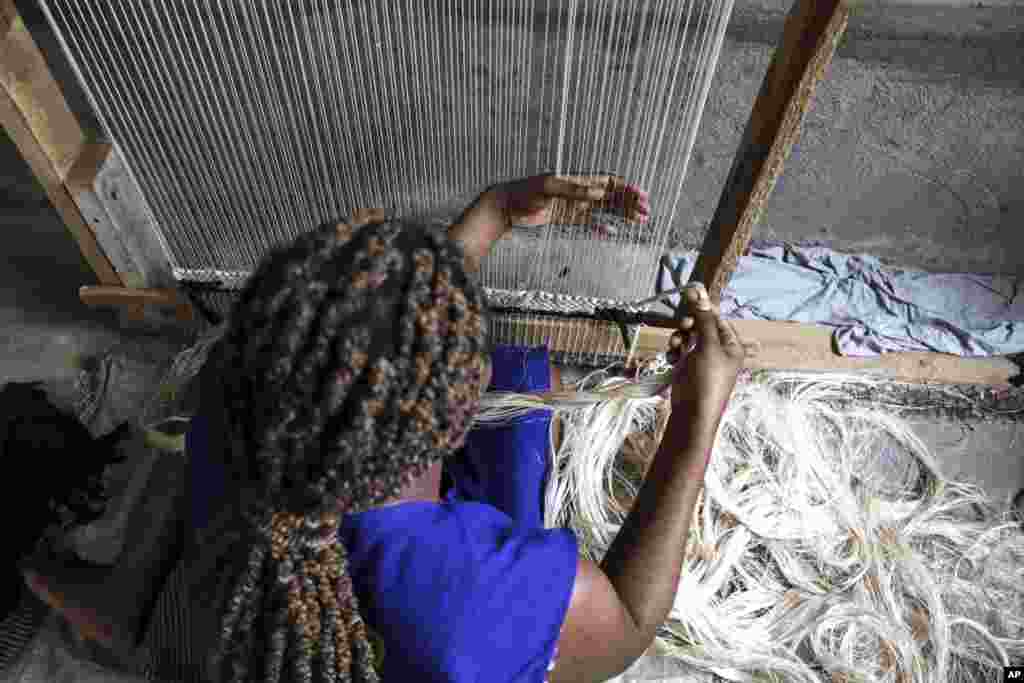 A worker weaves a carpet using banana fiber threads at TEXFAD factory in Sonde, Mukono District, Uganda, Sept. 20 2023. 