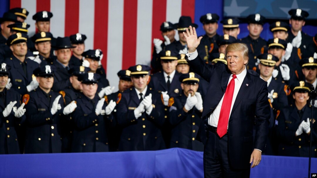 President Donald Trump waves after speaking to law enforcement officials on the street gang MS-13, July 28, 2017, in Brentwood, New York. 