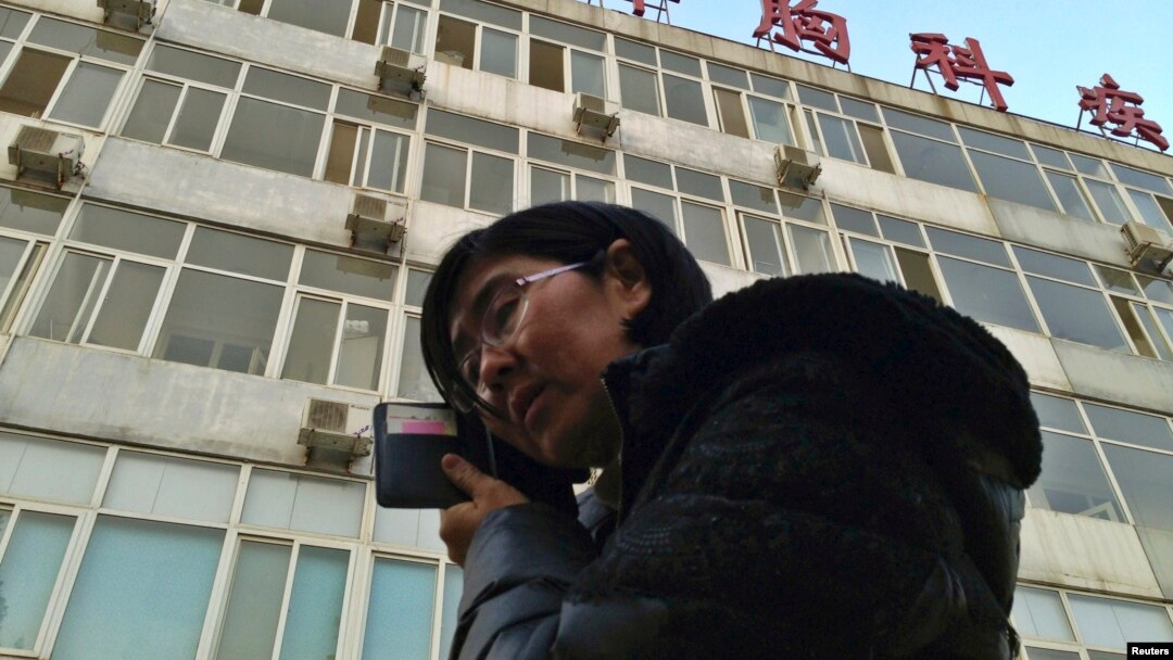 FILE - Wang Yu, the lawyer of human right activist Cao Shunli, talks on the phone in front of a hospital building where Cao was hospitalized at its intensive care unit in Beijing, March 1, 2014.