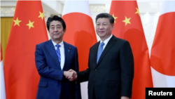 资料照片 - 中国国家主席习近平在北京人民大会堂会见日本首相安倍晋三。（2019年12月23日）