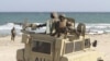 Peacekeepers from the African Union Mission in Somalia man weapons atop their Armored Personnel Carrier after capturing the former private Elmaan seaport from al-Shabaab insurgents, 30km (19 miles) east of Mogadishu, September 4, 2012. 