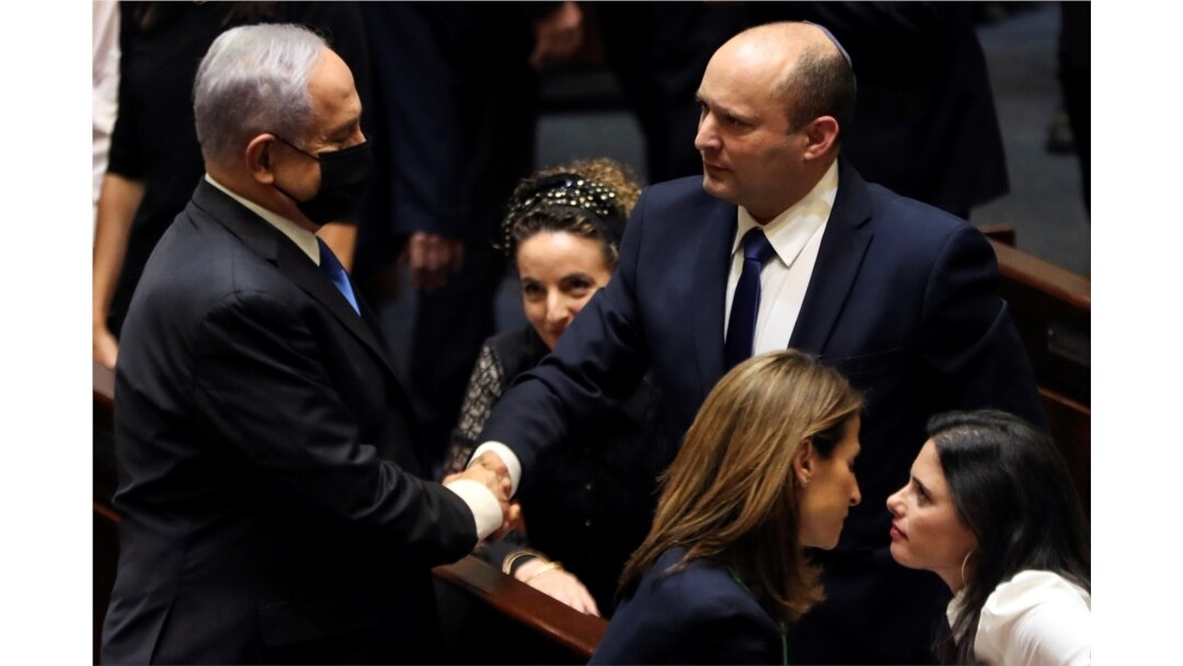 Benjamin Netanyahu (L) greets new Israel Prime minister Naftali Bennett following the vote on the new coalition at the Knesset, Israel's parliament, in Jerusalem June 13, 2021. (REUTERS/Ronen Zvulun)