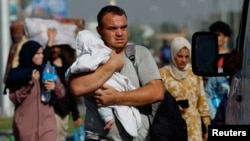Palestinians flee north Gaza towards the south, amid the ongoing conflict between Israel and Palestinian Islamist group Hamas, in the central Gaza Strip