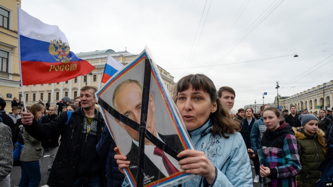 FILE - Opposition activists participate in a rally against Russian President Vladimir Putin, in Saint Petersburg, Russia, May 5, 2018.