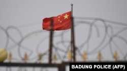 新疆喀什附近一个营地墙上的铁丝网和营地内的中国国旗。（2019年6月4日）