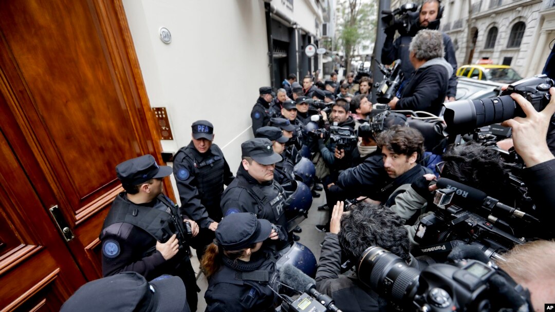 Police keep the press at bay as they execute a search warrant at the home of Senator and Former President Cristina Fernandez, in Buenos Aires, Argentina, Aug. 23, 2018.