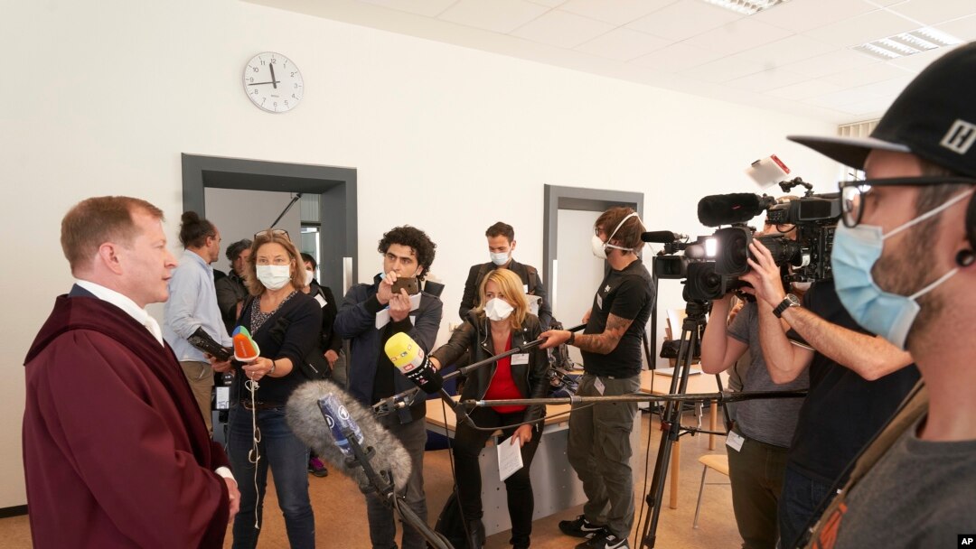Senior public prosecutor Jasper Klinge, left, talks to journalists at the Koblenz court building after the end of today's trial in Koblenz, Germany, Thursday, April 23, 2020. 