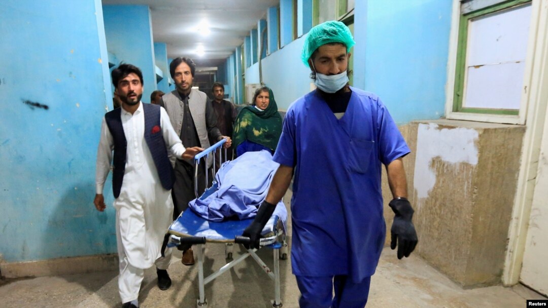 Afghan men transport the body of one of three female media workers who were shot and killed by an unknown gunmen, at a hospital in Jalalabad, Afghanistan, March 2, 2021.