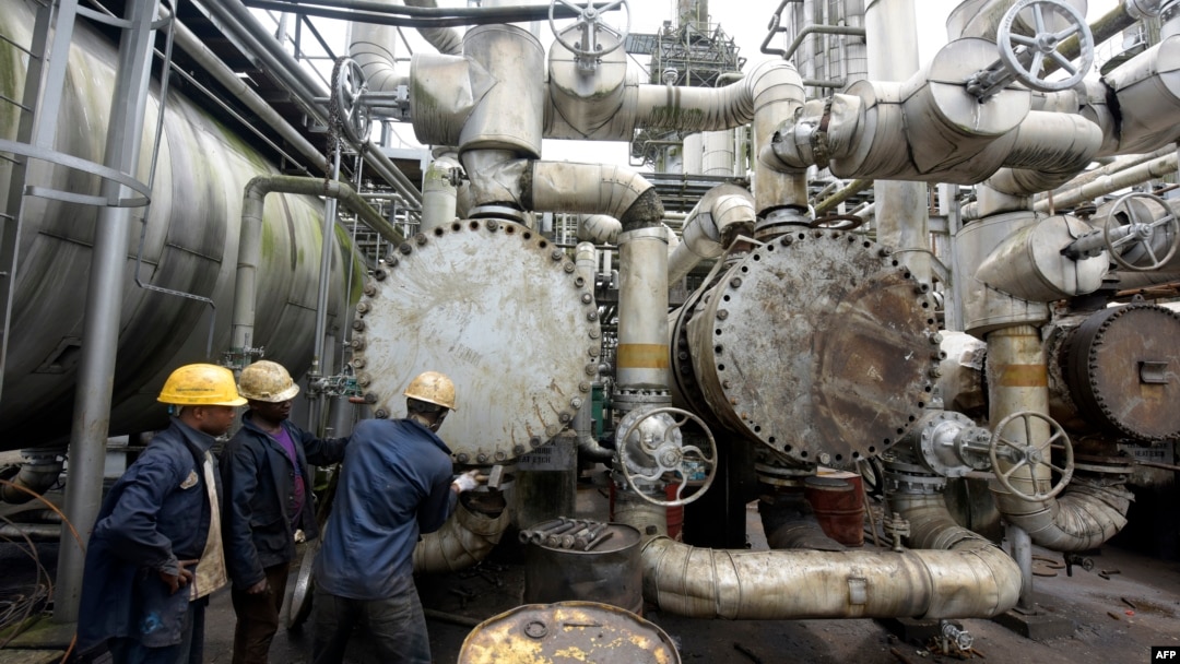 FILE - Workers try to tie a pipe at an oil refinery in Port Harcourt, Nigeria, Sept. 16, 2015. One of two state refineries in Port Harcourt will resume refining of crude oil in early August 2024, officials say.