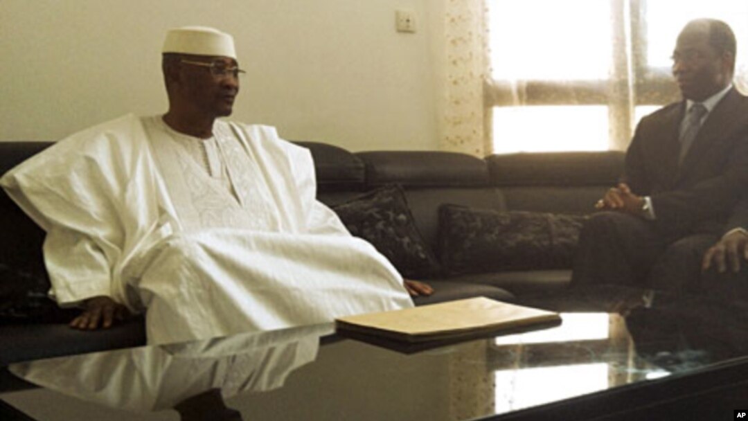 Mali's ousted President Amadou Toumani Toure (L) sits with Djibril Bassole, Burkina Faso's foreign minister and one of the leading mediators for West Africa's ECOWAS bloc, during a meeting in which Toure resigned in the capital Bamako, April 8, 2012. 