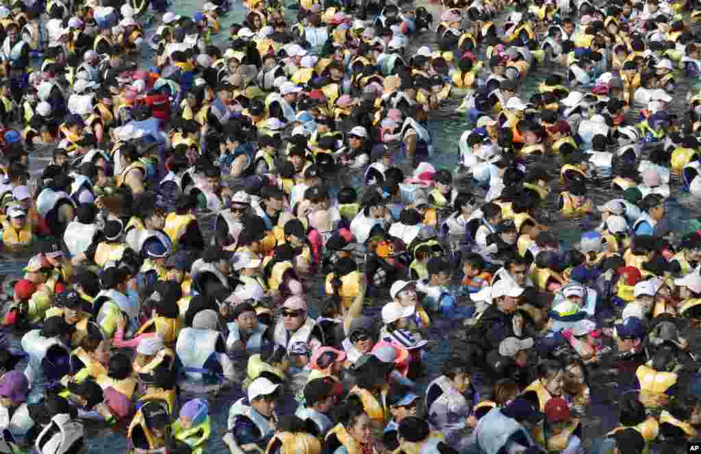 People crowd in the Caribbean Bay swimming pool trying to escape the heat in Yongin, South Korea.