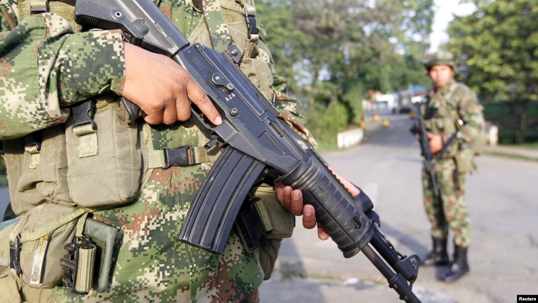 FILE- Colombian soldiers stand guard o a street in Caloto, Columbia, Feb. 6, 2014.