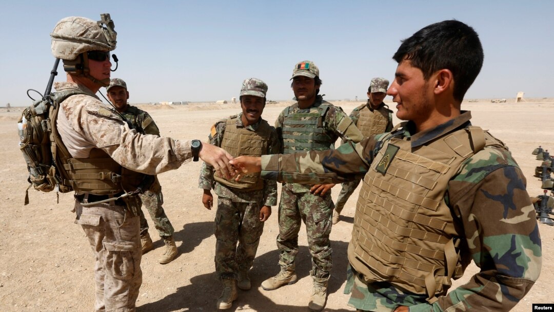FILE - A U.S. Marine shakes hands with Afghan National Army (ANA) soldiers during a training exercise in Helmand province, Afghanistan, July 5, 2017. Helmand was the scene of an errant U.S. drone strike Friday.