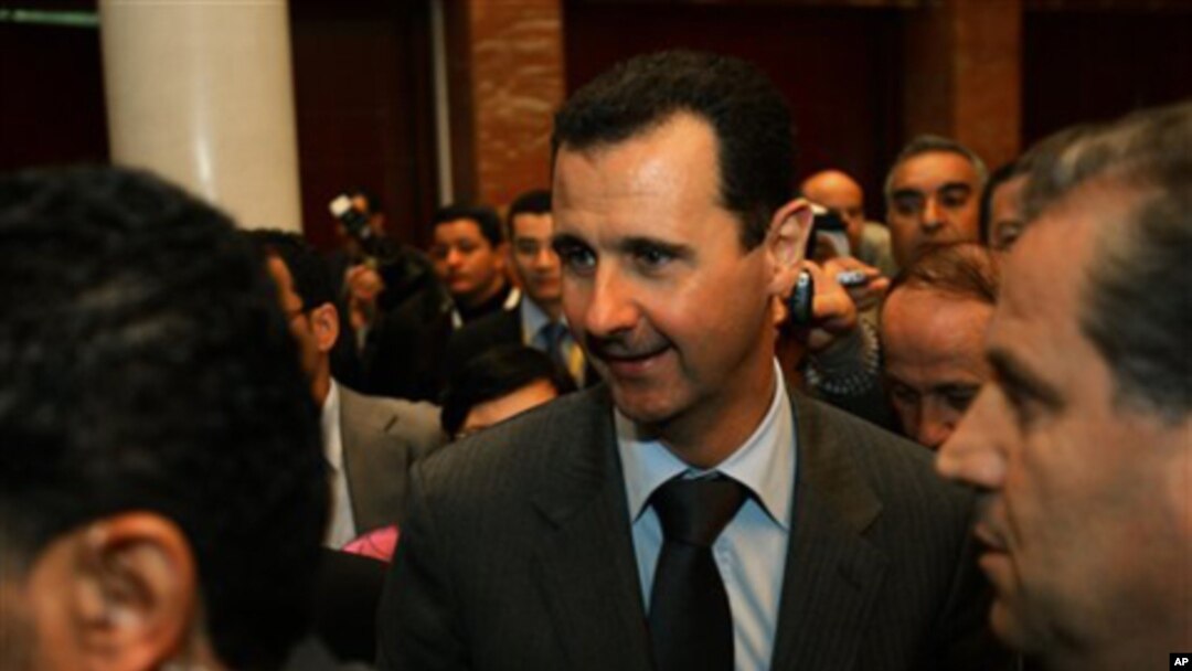 Syrian President Bashar al-Assad, center, after at the end of the second day closing session of the Arab League Summit in Sirte, Libya, (file photo)