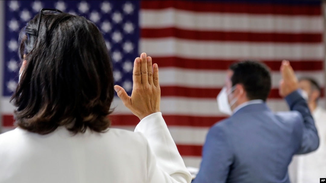FILE- In this July 2, 2020, file photo, people take the oath of citizenship during a naturalization ceremony at U.S. Citizenship and Immigration Service's Field Office in New York.