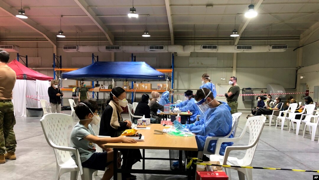 In this photo provided by the Australian Defence Force evacuees from Afghanistan are processed after arriving at Australia's main base in the Middle East region, Aug. 18, 2021, according to Australian defense. 