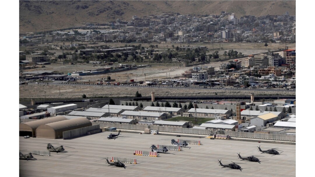 Kabul Military Airport where helicopters are parked are seen through a window of a commercial airplane, July 7, 2021.