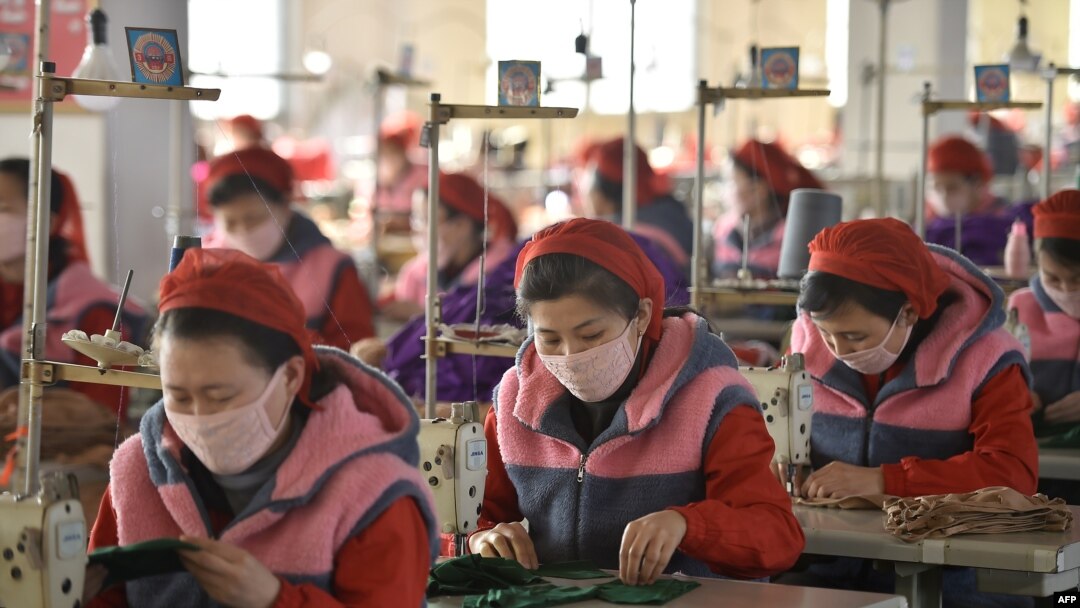 FILE - Workers produce masks for protection against the new coronavirus, at the Songyo Knitwear Factory in Pyongyang, Feb. 6, 2020.
