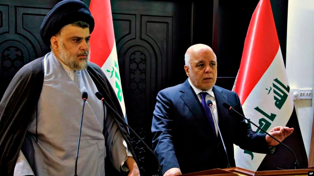 FILE - In this photo provided by the Iraqi government, Iraqi Prime Minister Haider al-Abadi, right, and Shiite cleric Muqtada al-Sadr hold a press conference in Baghdad, Iraq, May 20, 2018. 